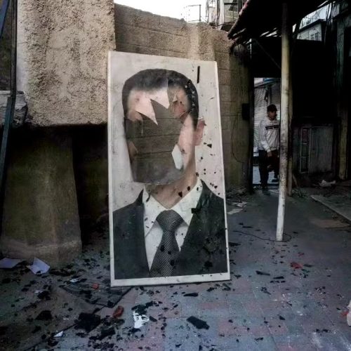 Síria: retrato rasgado do presidente sírio deposto Bashar al-Assad em uma instalação de segurança governamental saqueada, em Damasco, em 8 de dezembro de 2024.